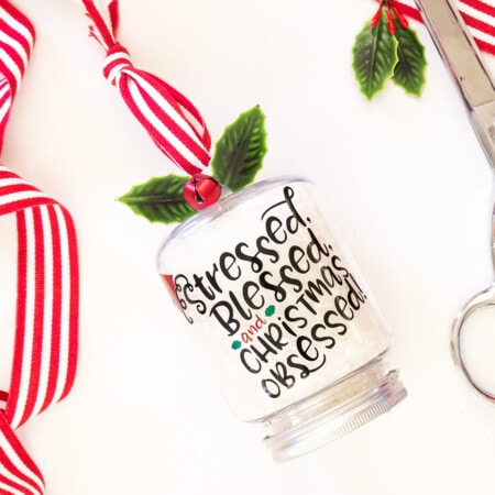 A Christmas ornament with ribbon next to it.