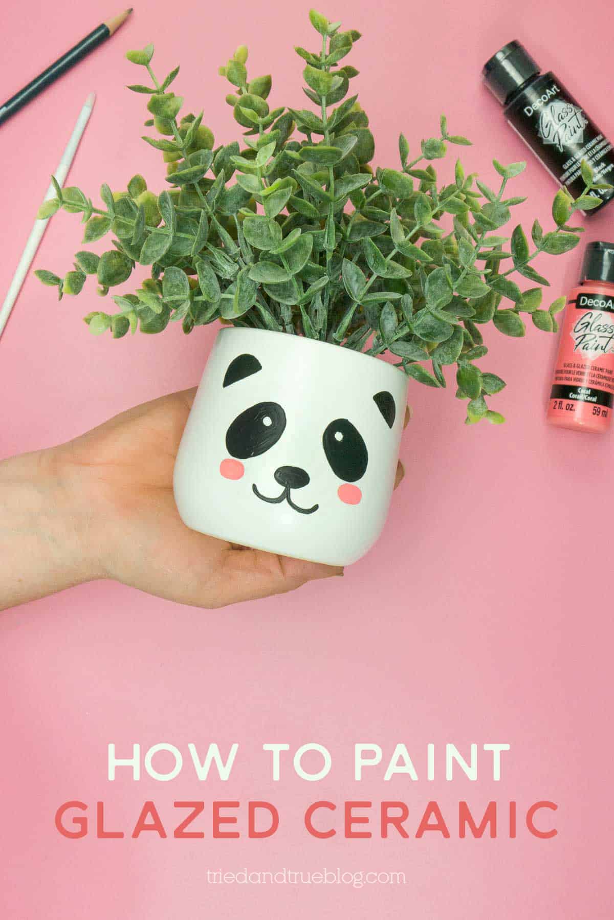 Hand holding white planter with painted panda face. Words include "How to paint glazed ceramic."