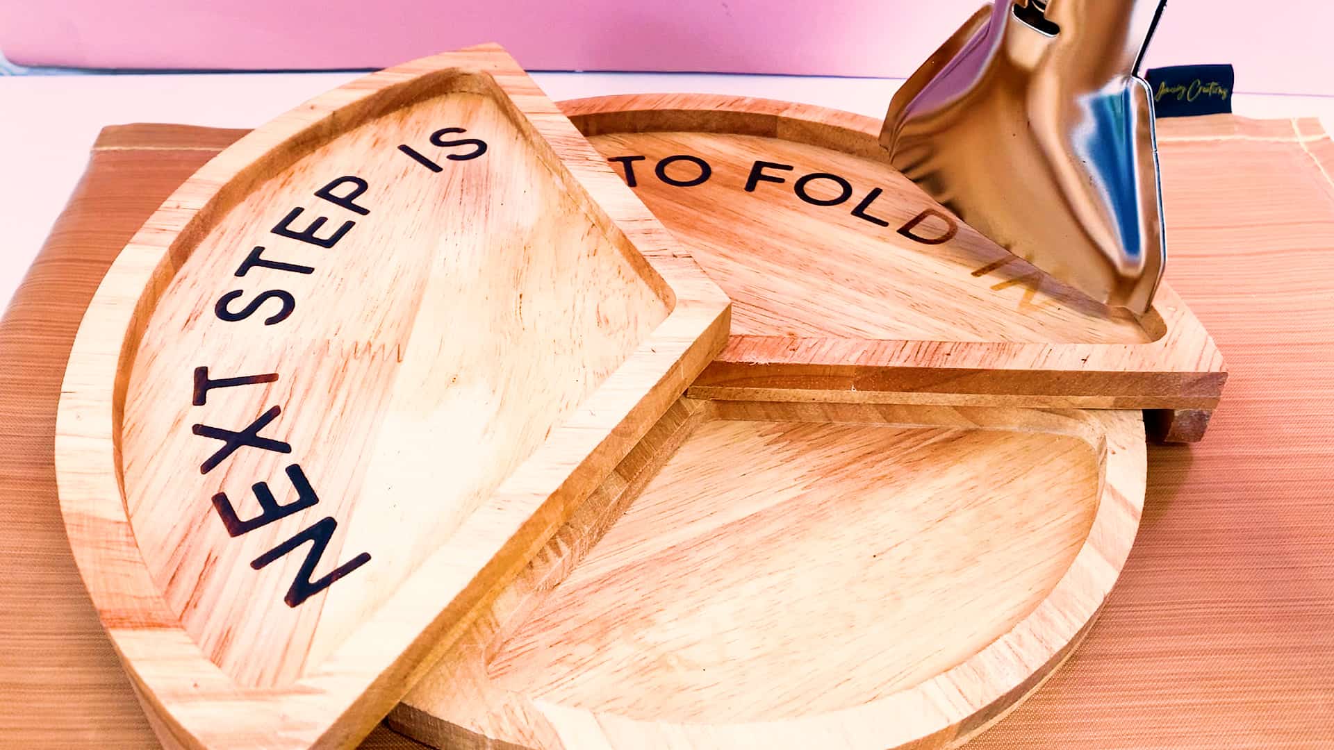 A wooden tray with the words next step to fold on it.