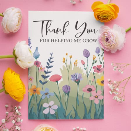 A Teacher Appreciation Seed Pack printable with floral illustrations surrounded by fresh tulips and ranunculus on a pink background.