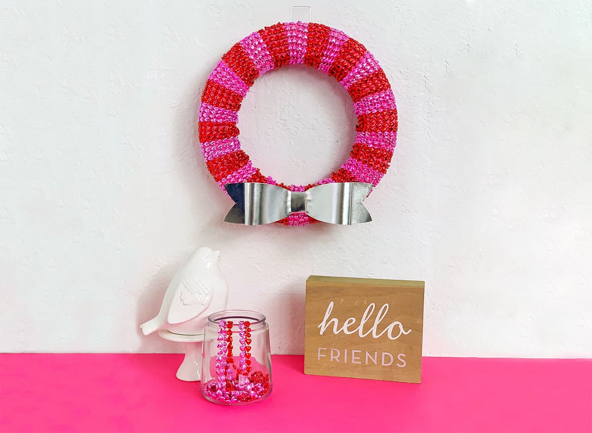 Metallic Dollar Store Valentine's Day Wreath on white background with pink flooring.